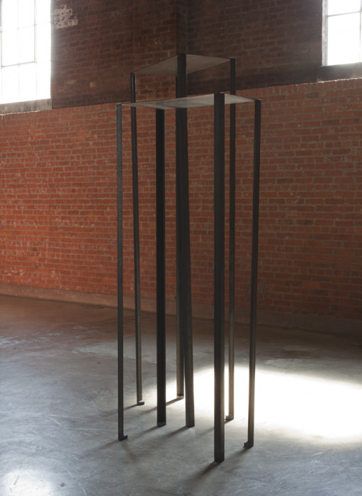 Two rectangular metal sheets lie flat across the tops of eight vertical metal poles.