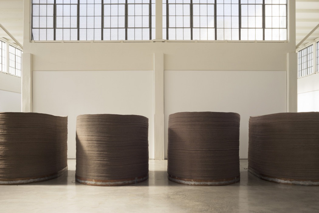 Four stacks of circular pieces of felt atop circular copper and iron base.