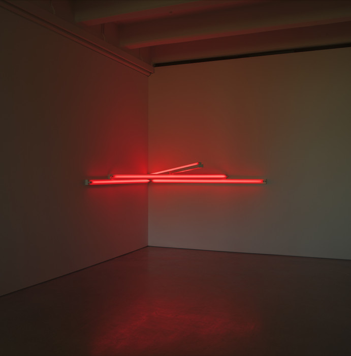 Red fluorescent horizontal tubes hang in the corner of a room.