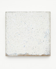 Square painting with thick, textured white paint with blue speckles showing through, on a tan canvas which is visible on the bottom edge.