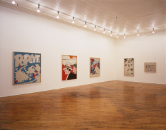 Five paintings on two adjacent white walls. The first three are large, colorful, and depict comic strip characters. The two on the far wall are mostly black and white and depict people.