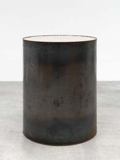A large steel tube-shaped vessel containing large chunks of salt. The steel is vary dark and dull, with various marks and smudges.