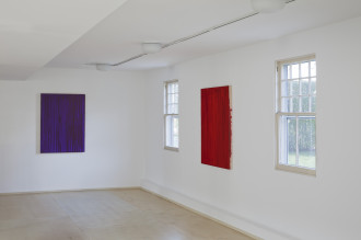 Two Jean-Luc Moulène paintings, a red rectangular canvas and a purple rectangualr canvas on adjacent white walls inside the Dia Bridghampton gallery
