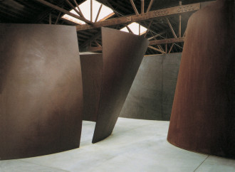 Tall, massive curvilinear structures fill a large space with concrete floors and a ceiling supported by wood beams.